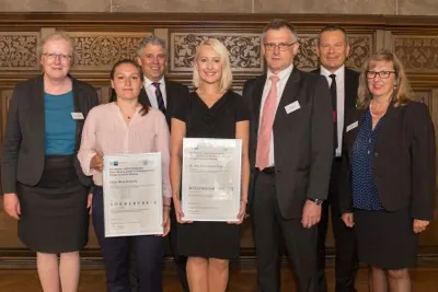Preisträgerinnen des IHK-Wissenschaftspreises 2015 sind die Zahnmedizinerin Dr. Simone Dudda (Mitte) und die Biologin Celine Mara Zumkeller (2.v.l.). Mit ihnen freuen sich Universitätspräsidentin Prof. Dr. Katharina Krause (links), der stv. Hauptgeschäftsführer der IHK Kassel-Marburg Oskar Edelmann (3.v.l.), der Regionalausschussvorsitzende der IHK Kassel-Marburg Peter Lather (3.v.r.), Oberbürgermeister Dr. Thomas Spies (2.v.r.) und die Stadtverordnetenvorsteherin der Universitätsstadt Marburg Marianne Wölk (rechts). Foto: Markus Farnung/Philipps-Universität Marburg
